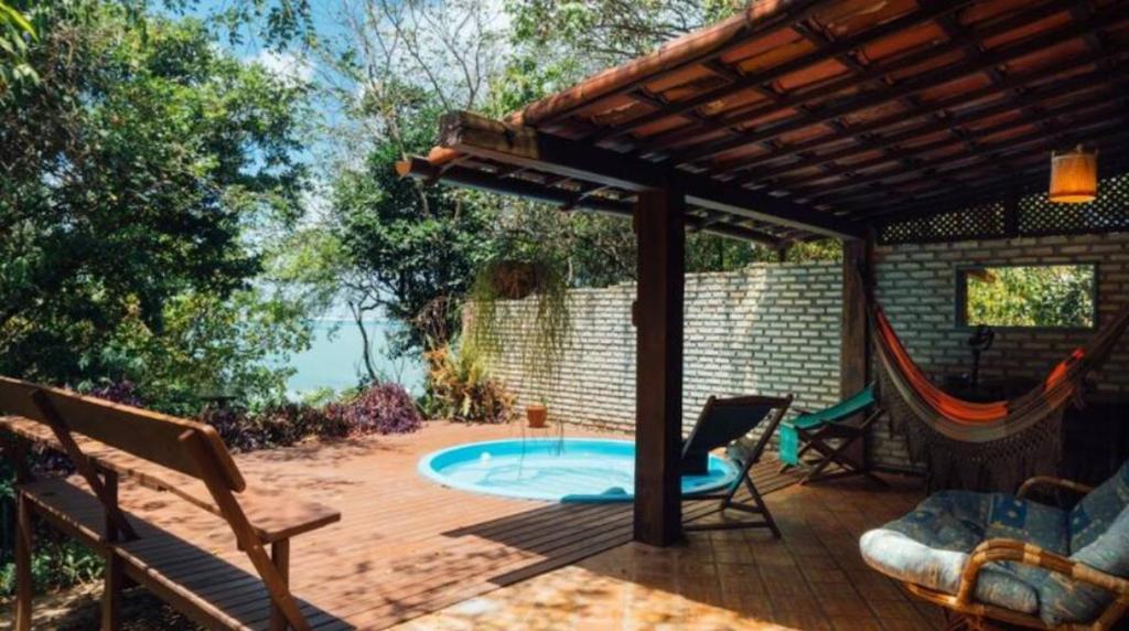 a patio with a hot tub and a pergola at Chalés Mirante de Pipa in Pipa