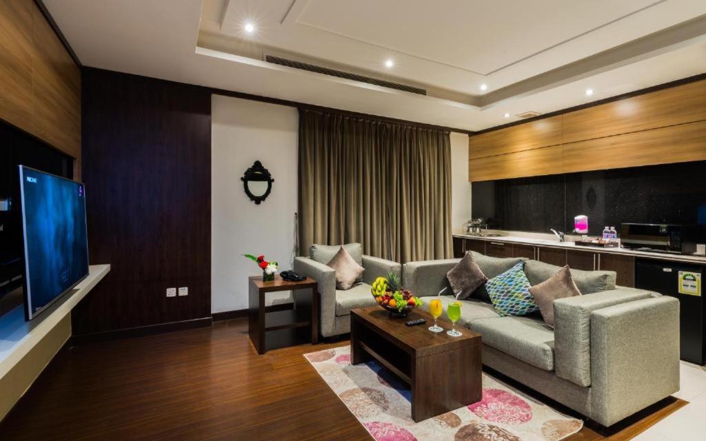 a living room with a couch and a tv at Myan Al Urubah Hotel in Riyadh