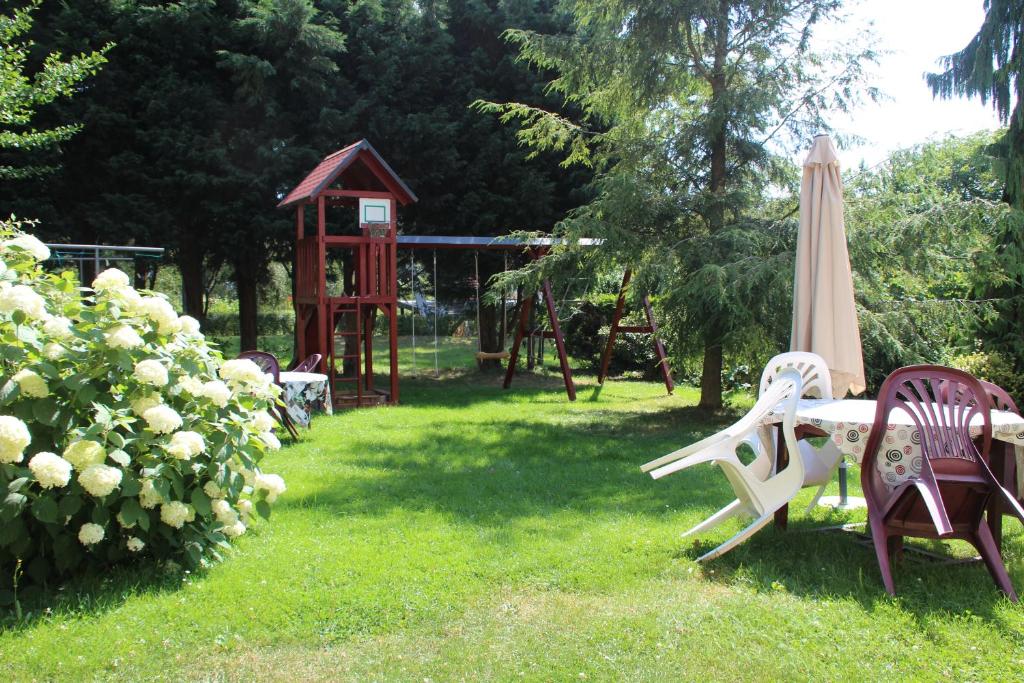 een tuin met een tafel en een schommel en een speelplaats bij Fewo Schillings in Kodersdorf