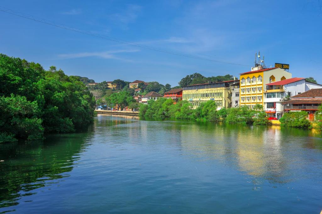um rio com edifícios ao lado dele em Hotel Sona em Panaji