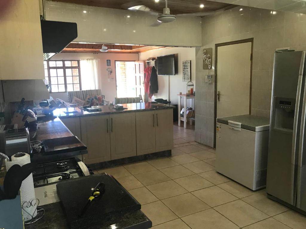 a kitchen with a stove and a refrigerator at Sibiya Guest House in Sodwana Bay