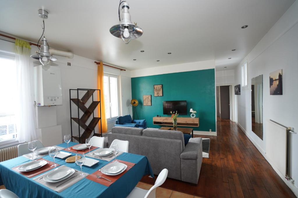 - un salon avec une table bleue et un canapé dans l'établissement Grand appart à 2 pas des bords de Loire, à Orléans