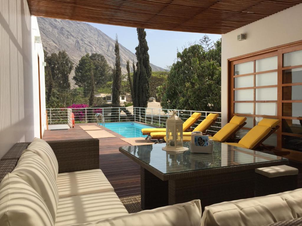 un patio con tavolo, sedie e piscina di Zen Home & Garden House a Cieneguilla
