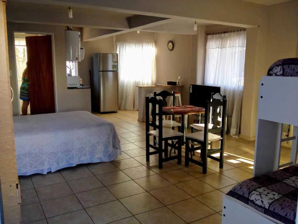 a bedroom with a bed and a table and chairs at Luminoso y bello departamento en Carlos Paz in Villa Carlos Paz