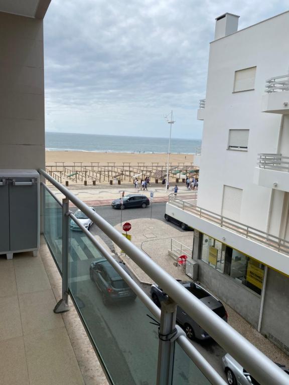 a balcony with a view of a beach and a building at Perola Mar in Nazaré