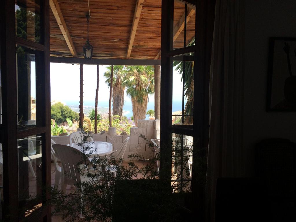 une maison avec vue sur un patio planté de palmiers dans l'établissement pequeño conjunto casas adosado, à Salobreña