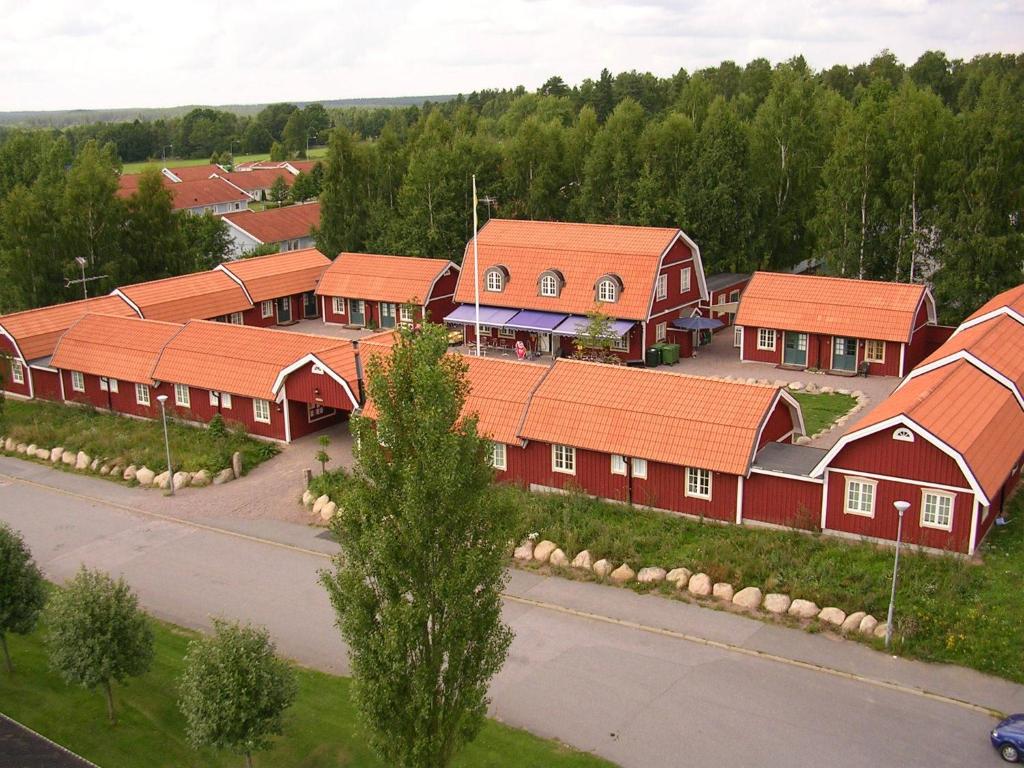 um grupo de edifícios vermelhos com telhados laranja em Oxgården em Vimmerby