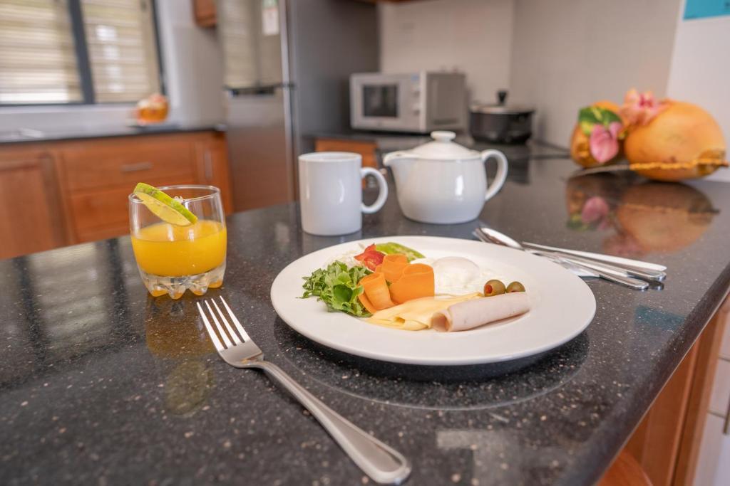 a plate of food on a counter with a glass of orange juice at Kolibri Holiday Apartments in Victoria