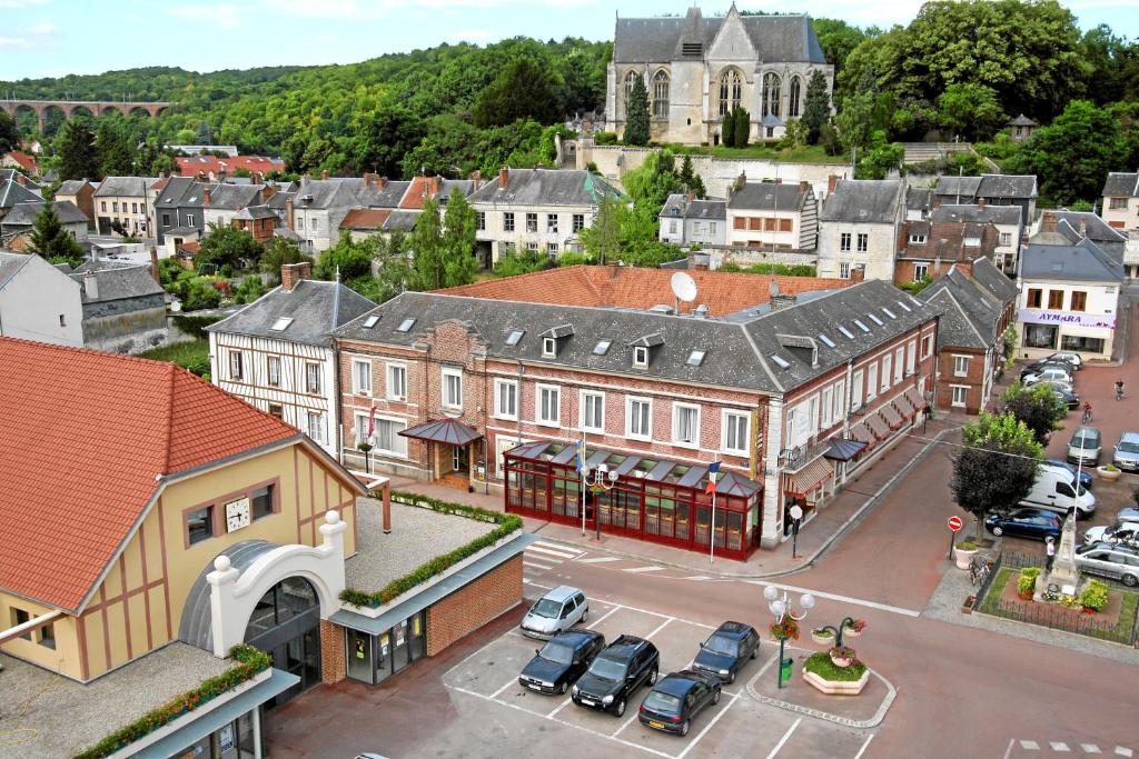 einen Blick über eine Stadt mit auf einem Parkplatz geparkt in der Unterkunft Hotel & Restaurant Le Cardinal in Poix