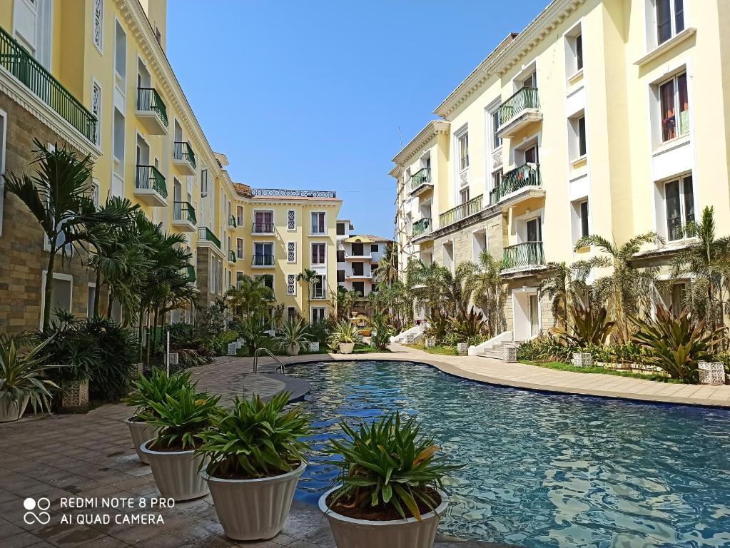 a swimming pool in the middle of some buildings at Areia De Goa Luxury Condo in Arpora