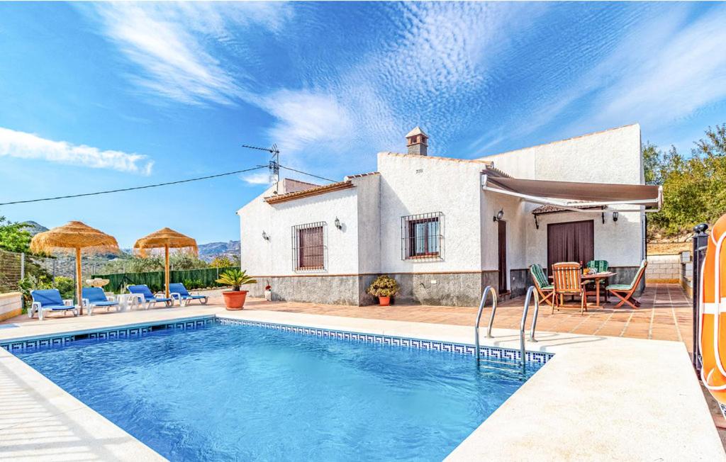 eine Villa mit einem Pool vor einem Haus in der Unterkunft Cortijo Sylvestris in Periana