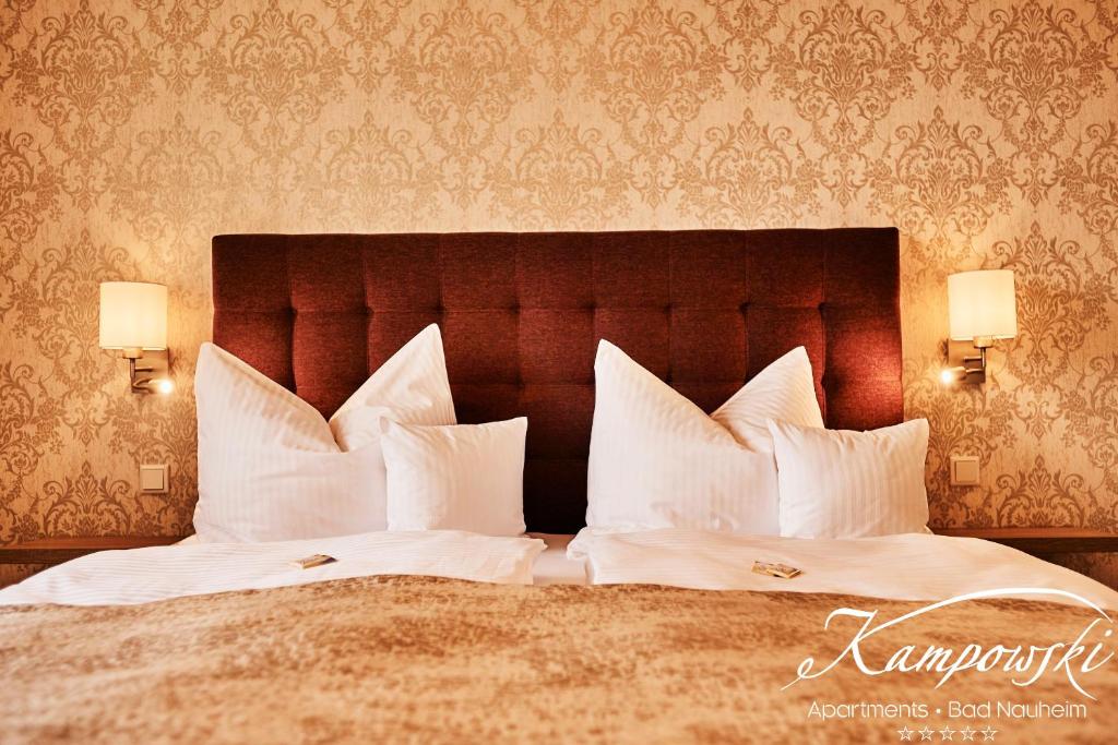 two beds with white pillows in a hotel room at Kampowski Apartments Deluxe in Bad Nauheim