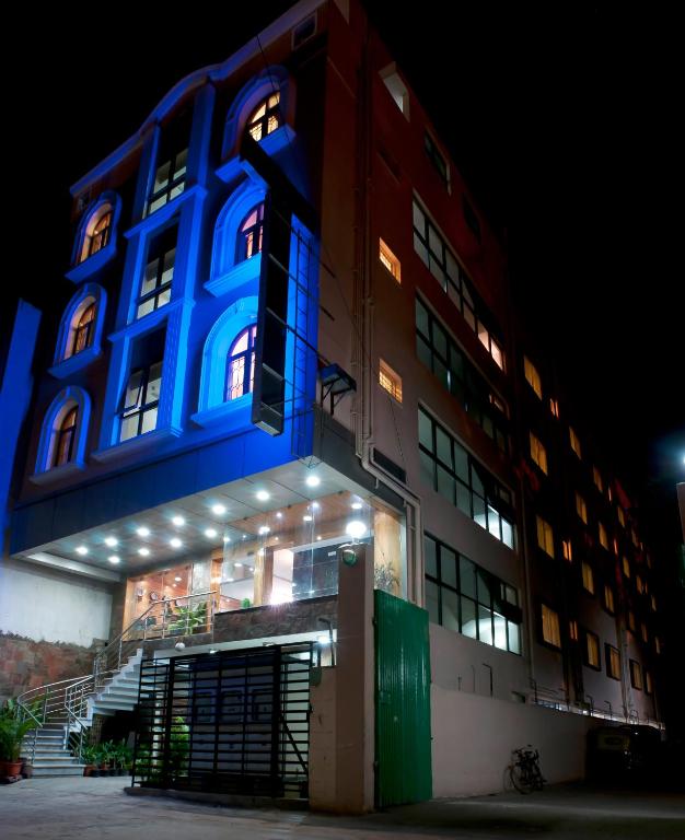 a building with a blue light on the side of it at Sheetal Residency in Bangalore