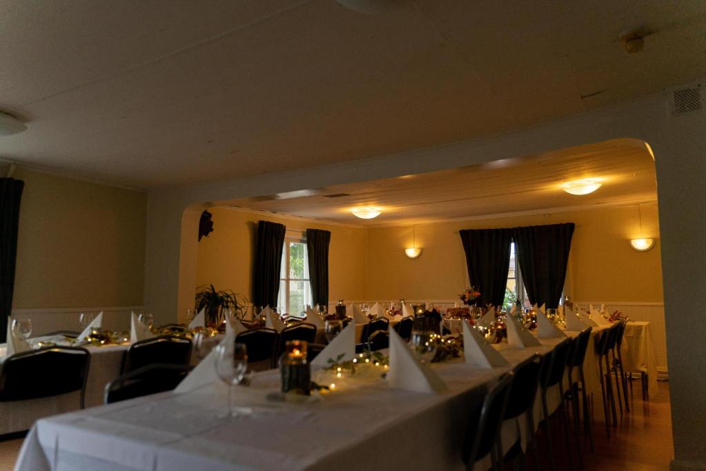 a room filled with tables and chairs with white table cloth at Djurgårdsportens vandrarhem in Mariefred