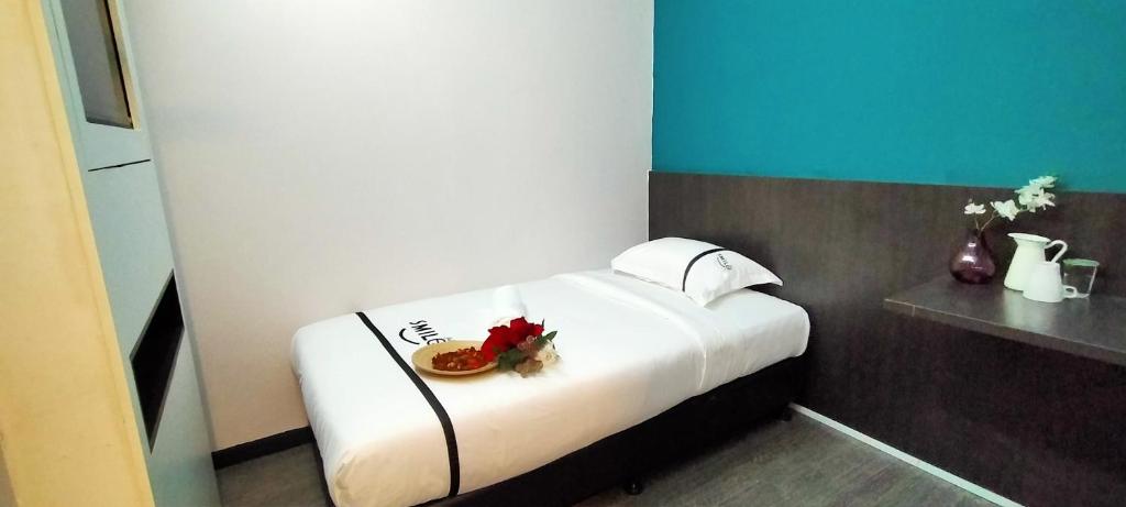 a bedroom with a bed with a plate of food on it at Smile Hotel Petaling Jaya SS2 in Petaling Jaya