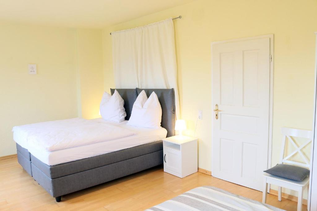 ベルギッシュ・グラートバッハにあるFerienwohnungen Domblick-Herkenrathのベッドルーム1室(白いシーツと枕のベッド1台付)