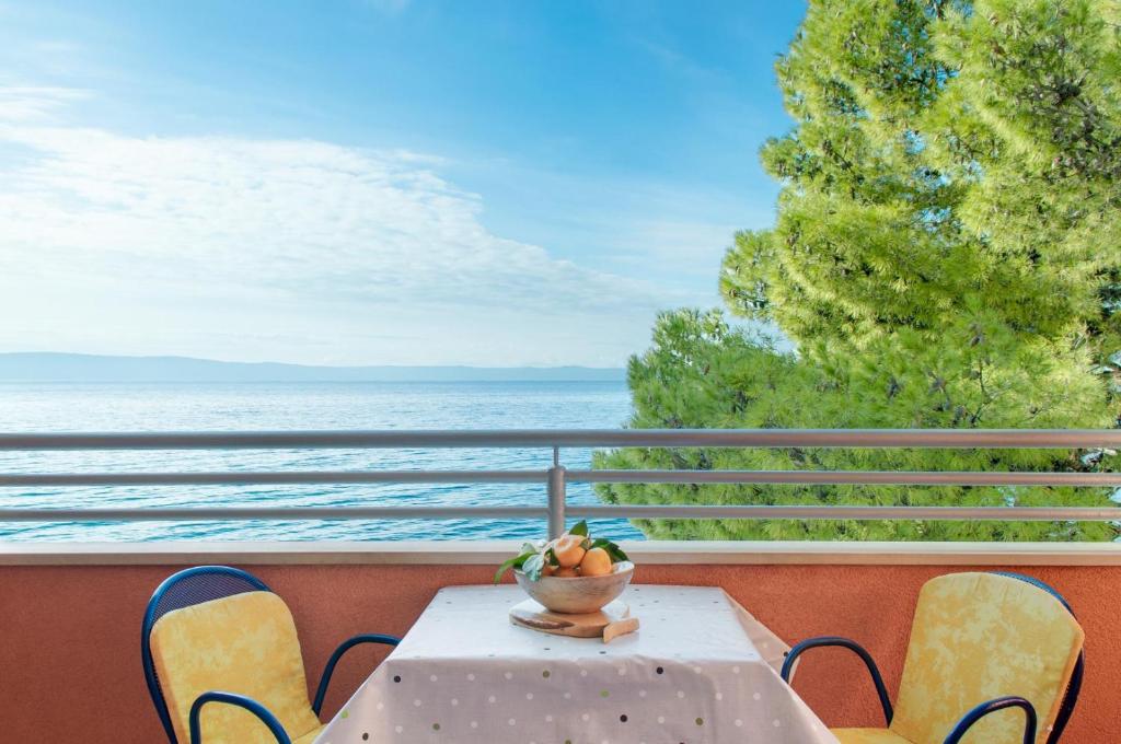 una mesa y sillas en un balcón con vistas al océano en Apartments Promenada - Beachfront, en Tučepi