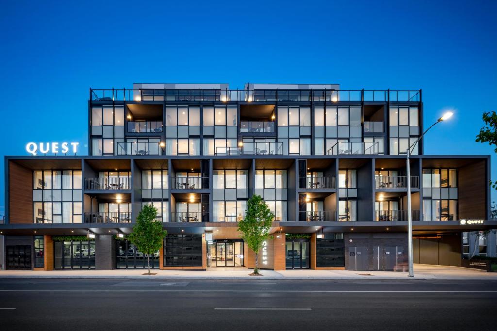 un edificio de apartamentos con una fachada iluminada por la noche en Quest Preston, en Melbourne