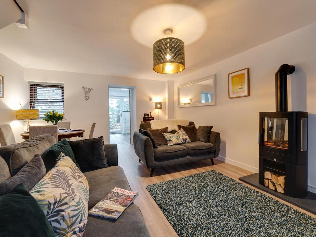 a living room with a couch and a fireplace at 2 Ysgoldy in Bangor