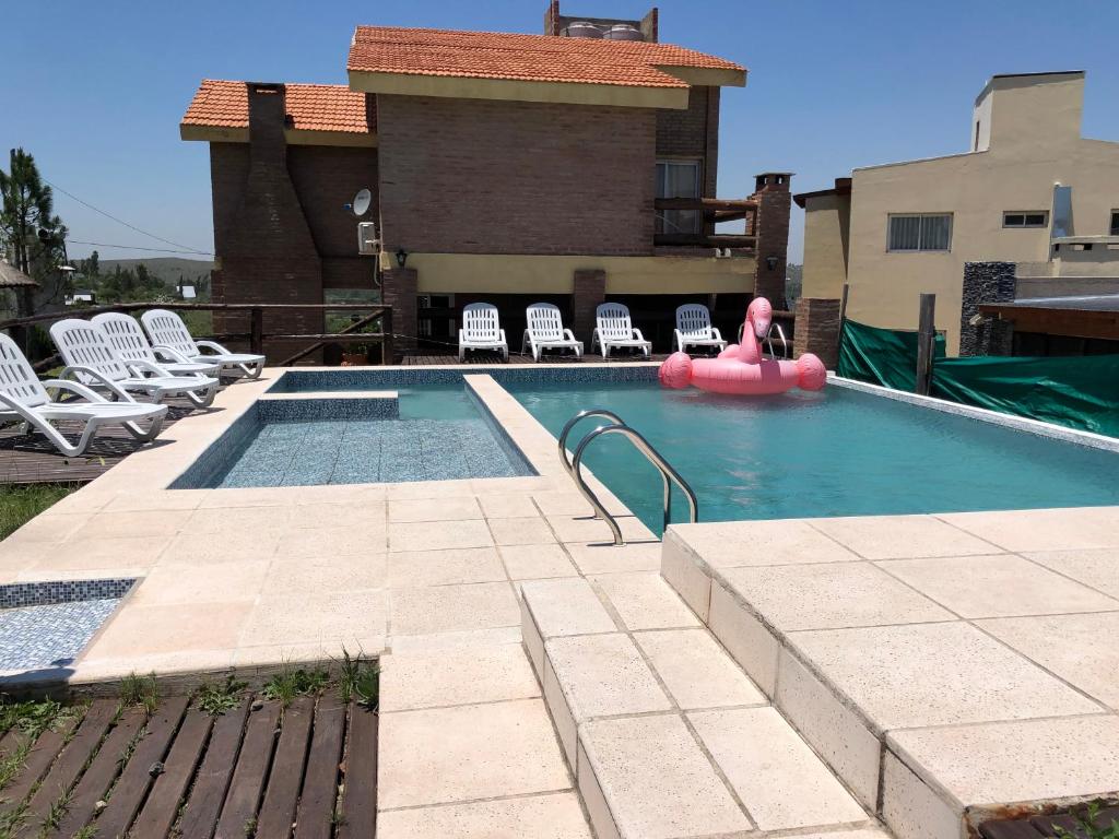 einen Pool mit einem rosa Schwimmer in einem Haus in der Unterkunft Terrazas De Potrero in Potrero de Garay