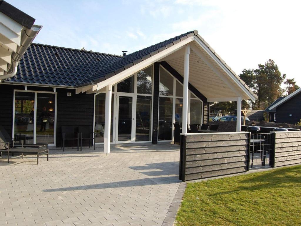 een afgeschermde veranda met een dak en een patio bij Holiday home Blåvand CLX in Blåvand