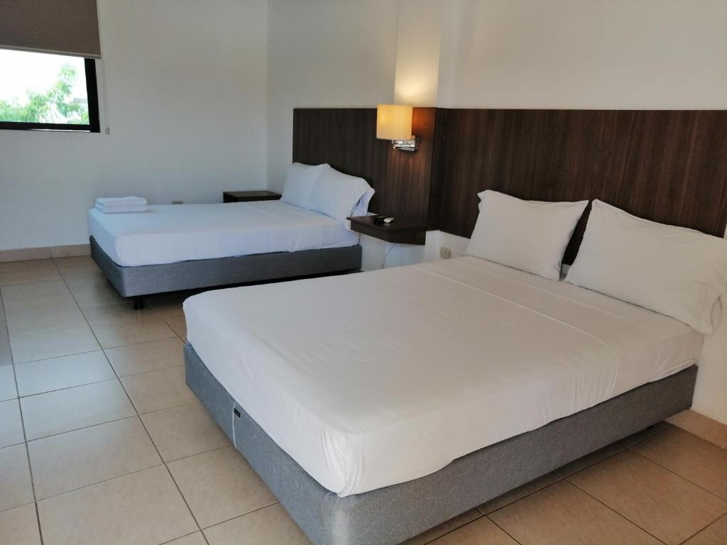 Postel nebo postele na pokoji v ubytování Buenavista Place Hotel