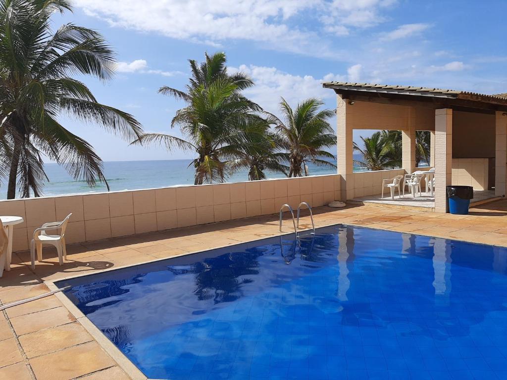 a swimming pool with a view of the ocean at Village Praia do Flamengo frente mar in Salvador