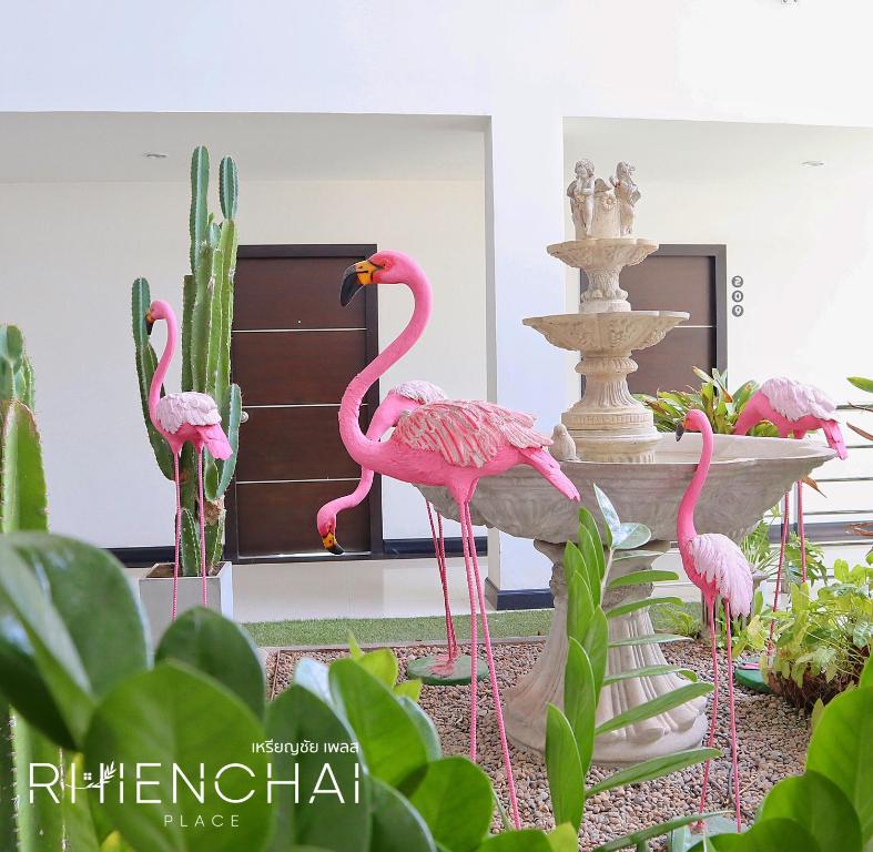 a group of pink flamingos in front of a fountain at Rhienchai Place Hotel in Surat Thani