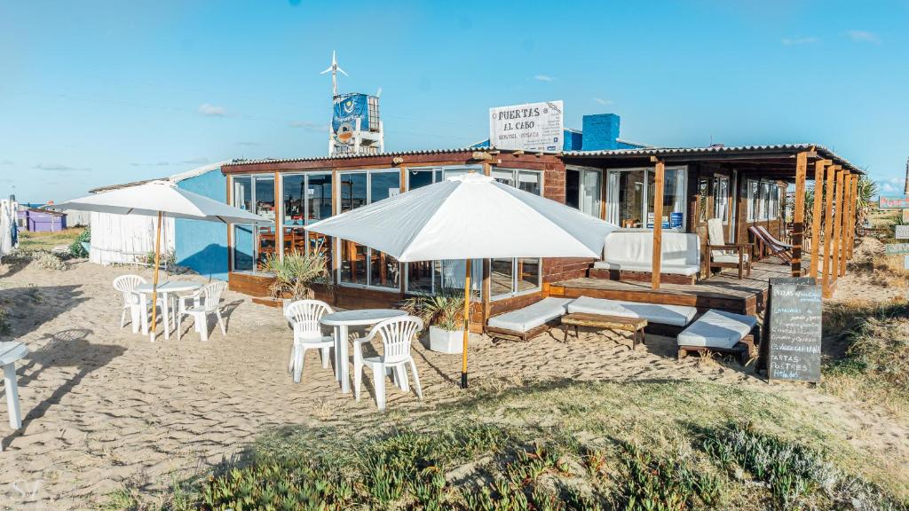 ein Strand mit Stühlen und Sonnenschirmen sowie ein Gebäude in der Unterkunft Puertas al Cabo in Cabo Polonio