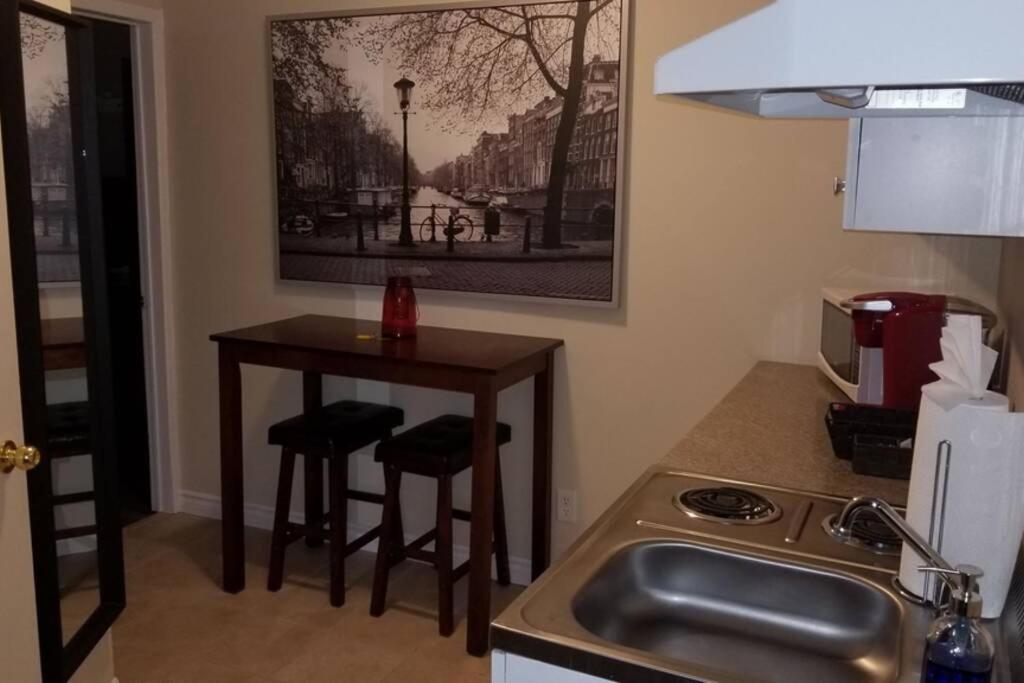 uma cozinha com um lavatório e uma mesa com bancos em Cozy 1-BDR Suite #20 by Amazing Property Rentals em Gatineau