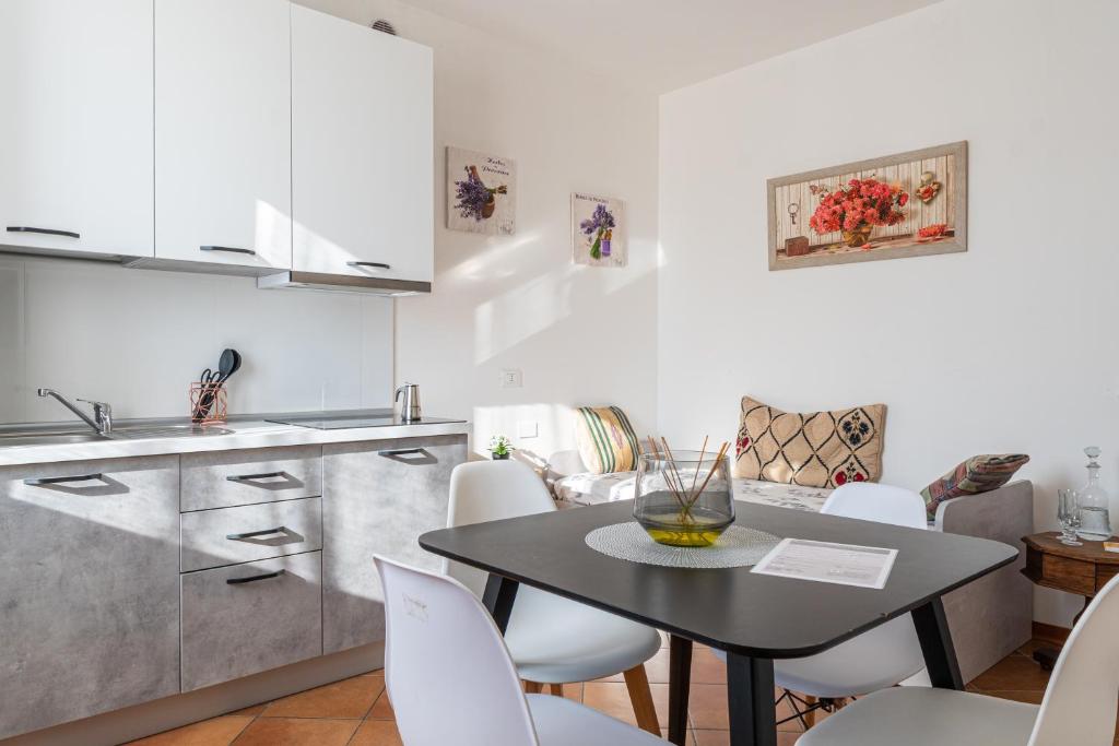 a kitchen with a black table and white chairs at Gold Oasi - Business Solution in Ferrara