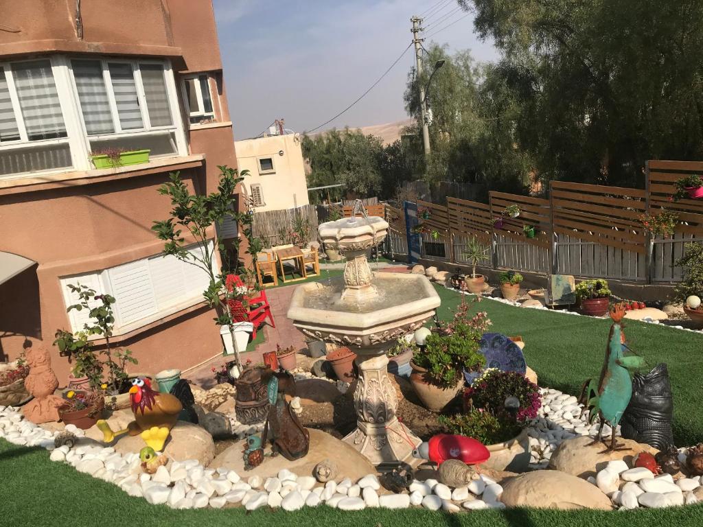 a garden with a fountain in the middle of a yard at סוויטות עין השמש eye sun in Arad