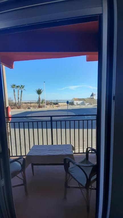 stół i krzesła na balkonie z widokiem na plażę w obiekcie el molino de viento flat w mieście San Pedro del Pinatar