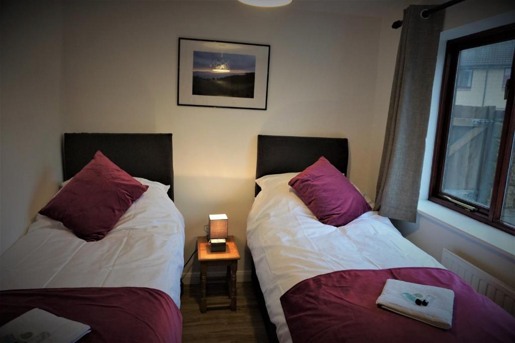 een slaapkamer met 2 bedden en een bijzettafel bij Palmers Apartment A in Bristol