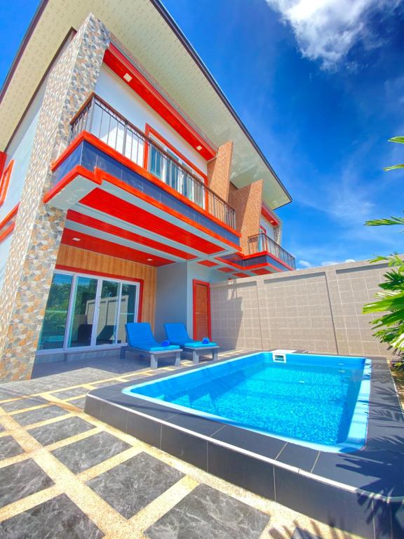 a house with a swimming pool in front of a house at Blue Aura Pool Villa in Nai Yang Beach