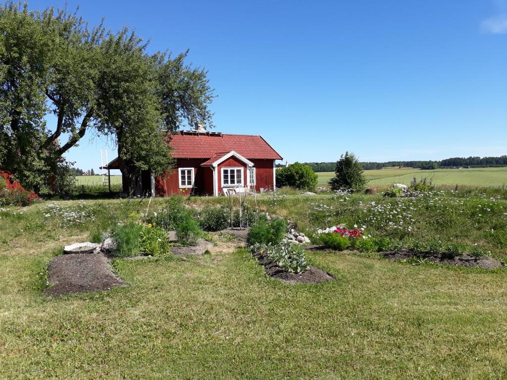 uma pequena casa vermelha num campo com jardim em Pilgården Fornåsa, Drängstugan 