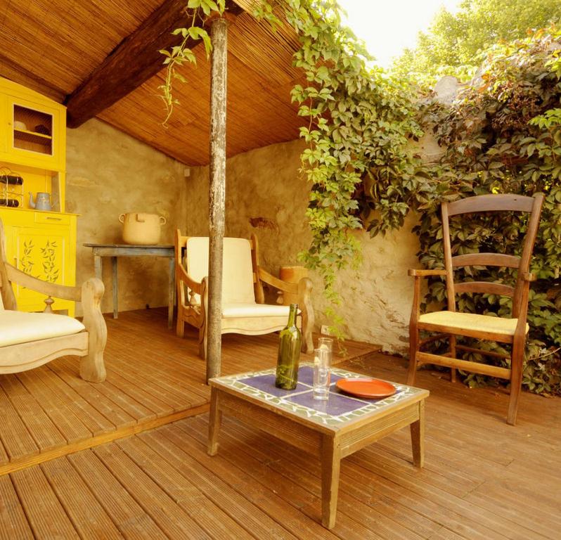une terrasse avec des chaises et une table ainsi qu'une chambre avec dans l'établissement La Vigne Bleue, à Olonzac