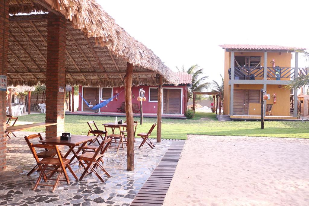 un patio avec des tables et des chaises ainsi qu'une aire de jeux dans l'établissement Pousada Lagunas, à Ponta do Anel