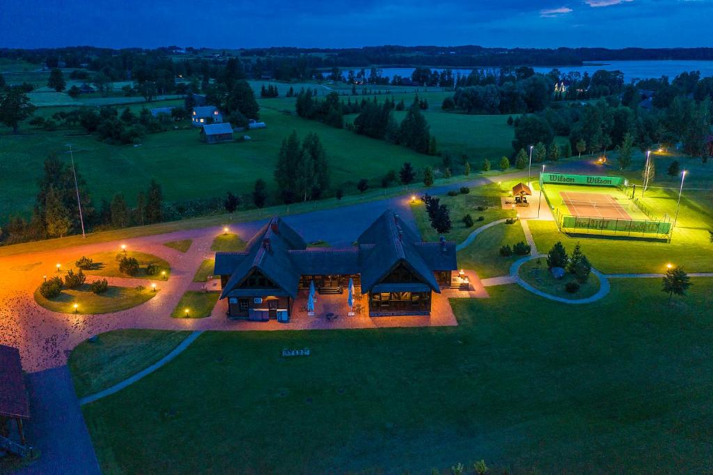 una vista aérea de una casa grande con luces encendidas en Alauso Slenis, en Sudeikiai