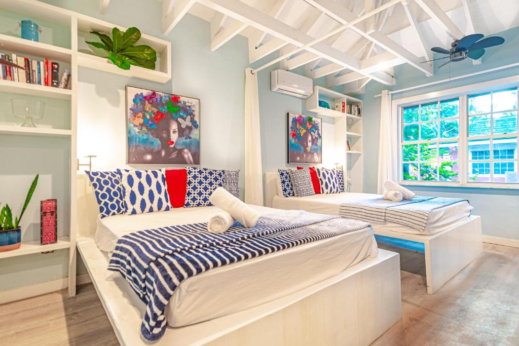 a bedroom with two beds and a window at Butterfly Cottage at Viking Hill - Love Beach in Nassau