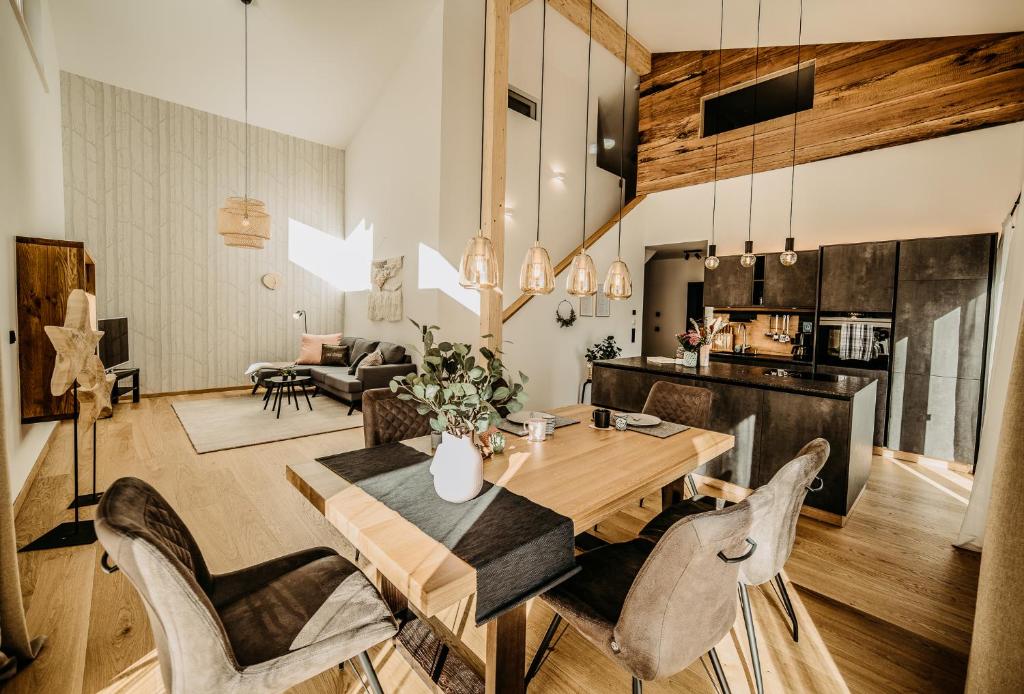 uma sala de jantar e sala de estar com uma mesa de madeira e cadeiras em Haus Wildmoos em Sankt Martin bei Lofer