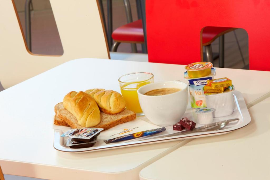 a tray of breakfast foods and coffee on a table at Première Classe Roissy - Aéroport CDG - Le Mesnil-Amelot in Le Mesnil-Amelot