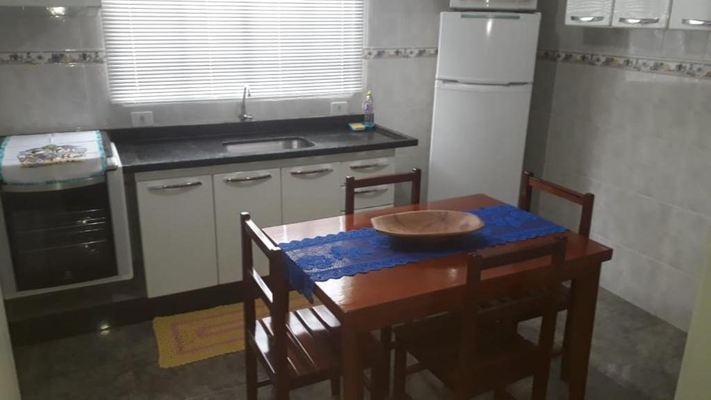 Casa em Olímpia في أوليمبيا: مطبخ مع طاولة خشبية مع وعاء عليه