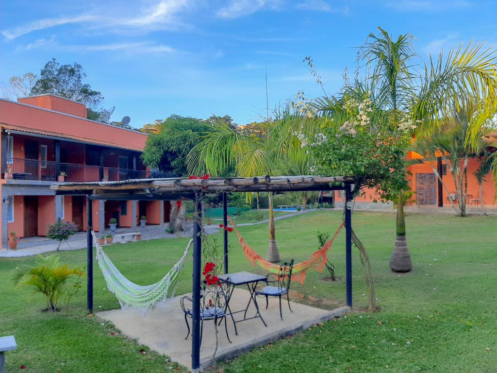 eine Hängematte und ein Tisch und Stühle im Hof in der Unterkunft Villa Terracotta in Miguel Pereira