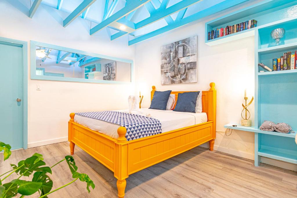 1 dormitorio con cama amarilla y techos azules en Studio Candy at Viking Hill - Love Beach, en Nassau
