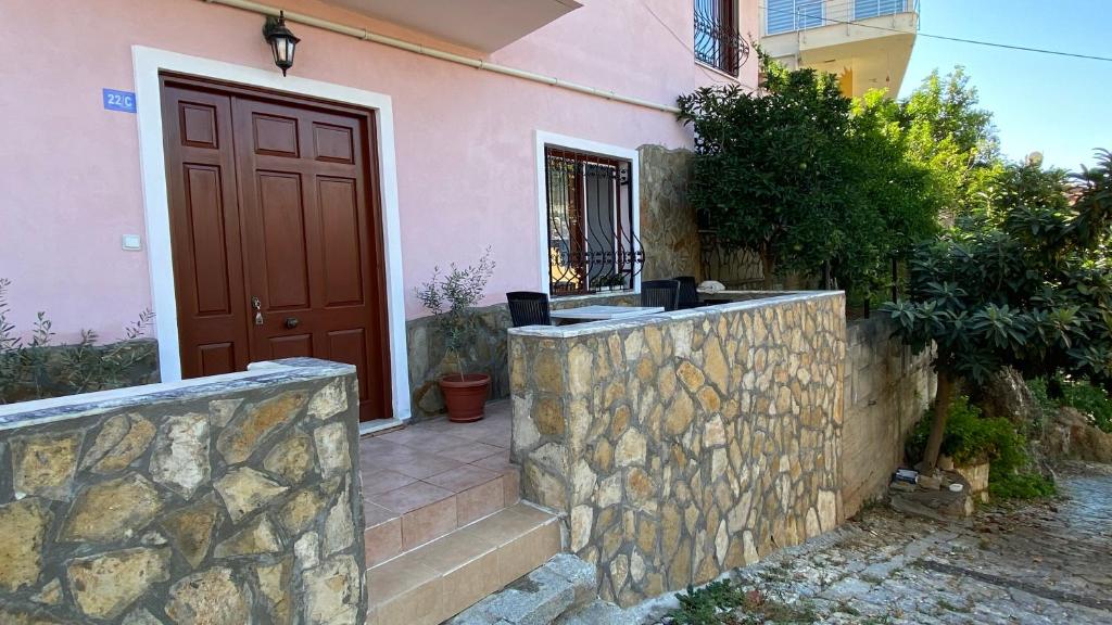 une maison avec une porte rouge et un mur en pierre dans l'établissement Authentic Flat on the Castle Road with a View, à Alanya