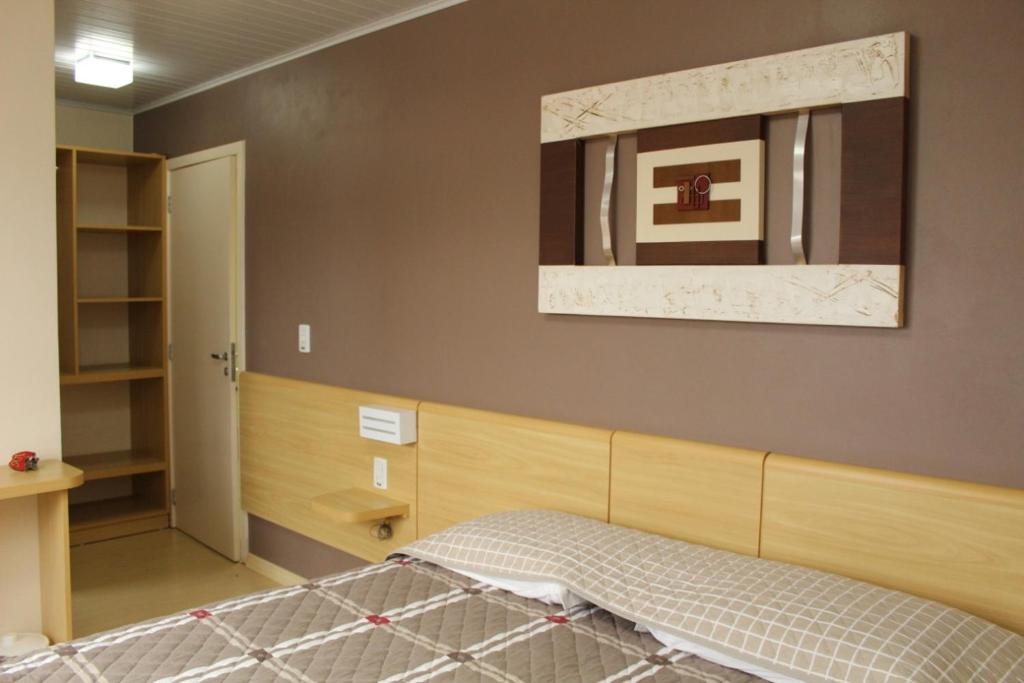 um quarto com uma cama e um espelho na parede em Hotel Cesa em São José dos Ausentes