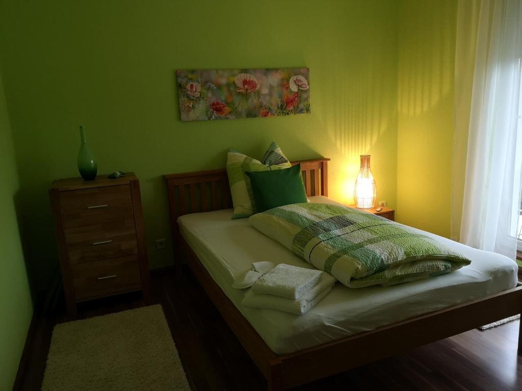 Dormitorio verde con cama con vestidor y ventana en Ninas B&B - exklusiv für Frauen en Bremen