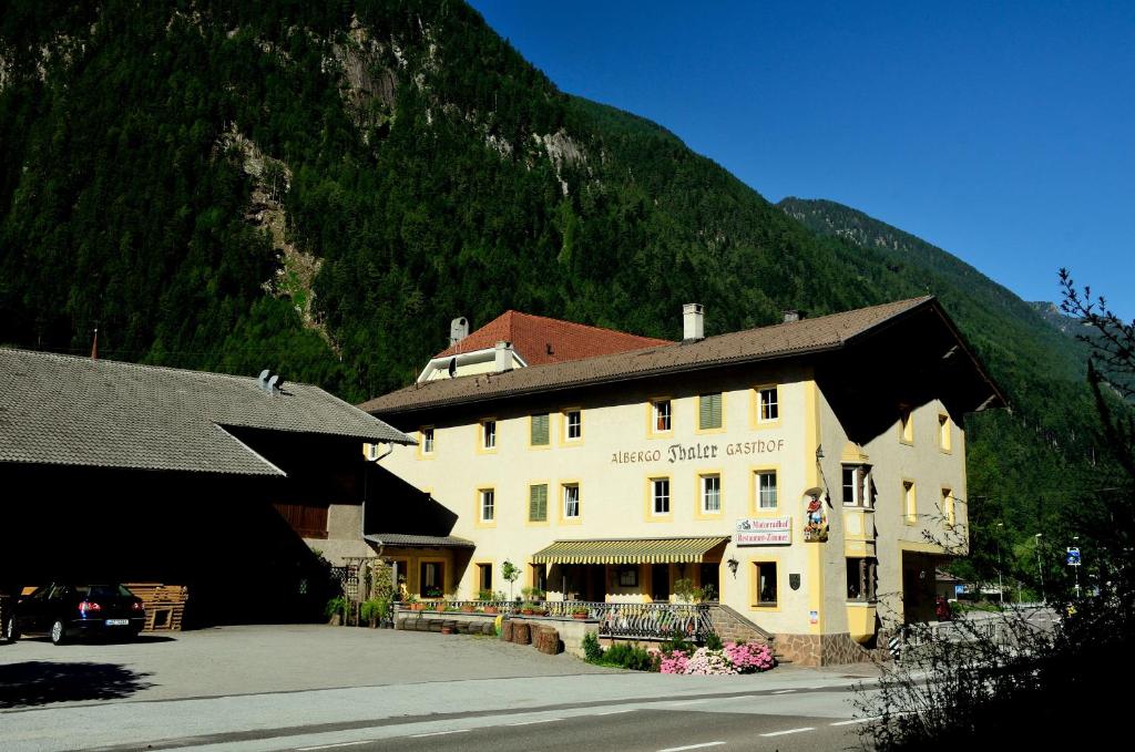 ein großes Gebäude vor einem Berg in der Unterkunft Gasthof Thaler 