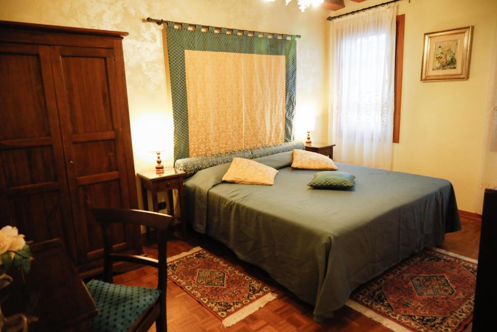 ein Schlafzimmer mit einem Bett, einem Fenster und einem Stuhl in der Unterkunft Appartamento San Marco Frezzaria in Venedig